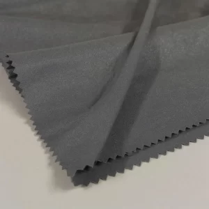 Muestra de tela Neocrep negra doblada sobre fondo neutro con iluminación suave de estudio