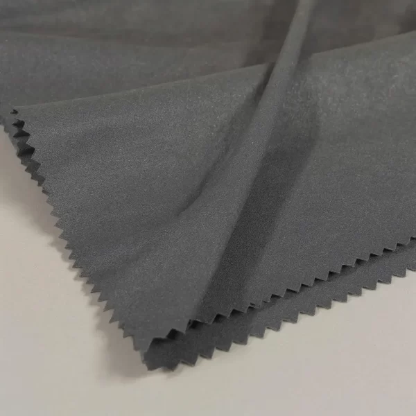 Muestra de tela Neocrep negra doblada sobre fondo neutro con iluminación suave de estudio